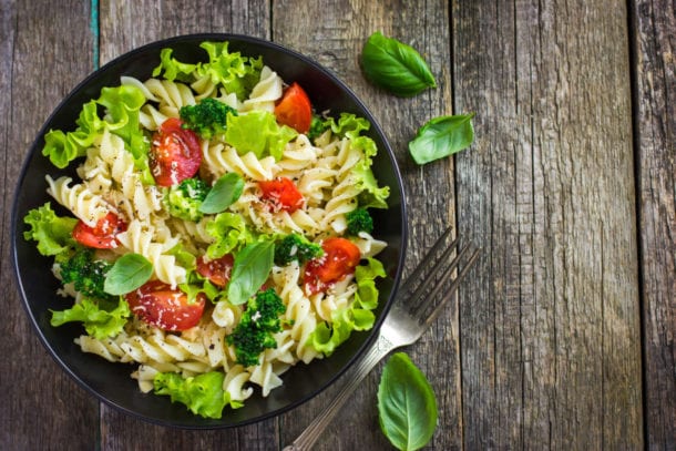 Pasta salad with cherry tomatoes and broccoli, top view